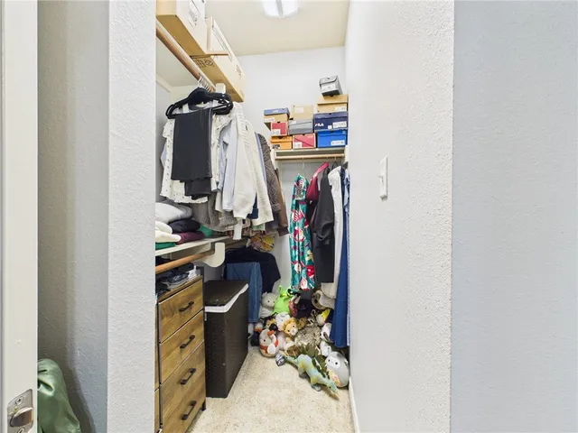 a view of walk in closet with clothes and shoes