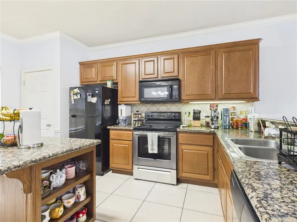 a kitchen with stainless steel appliances granite countertop a stove top oven a sink and dishwasher