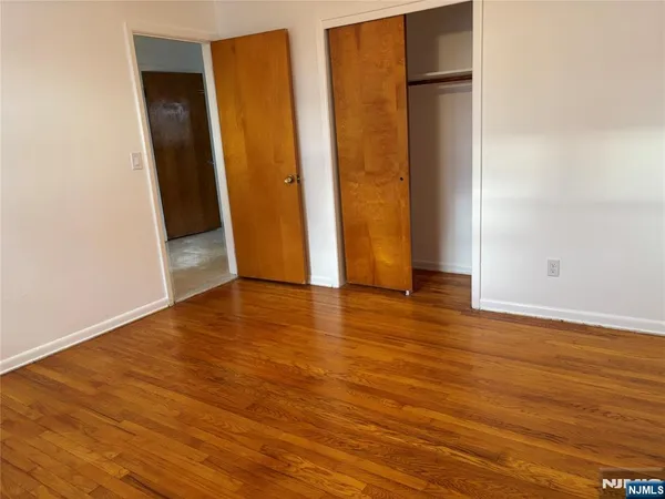an empty room with wooden floor and closet
