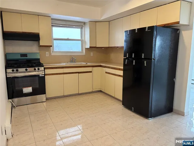 a kitchen with granite countertop a refrigerator and a sink