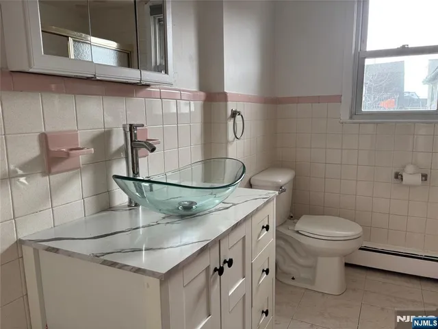a bathroom with a granite countertop toilet sink and mirror