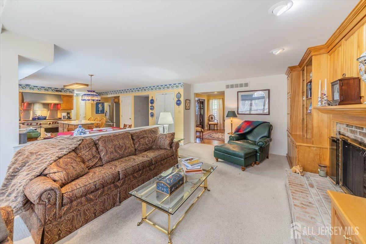 12 Adams Road Kendall Park, NJ 08824 - Photo 12 of 40 a living room with furniture a fireplace kitchen view and a large window