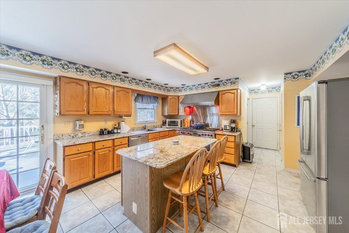 12 Adams Road Kendall Park, NJ 08824 - Photo 15 of 40 a kitchen with stainless steel appliances granite countertop a sink and a refrigerator