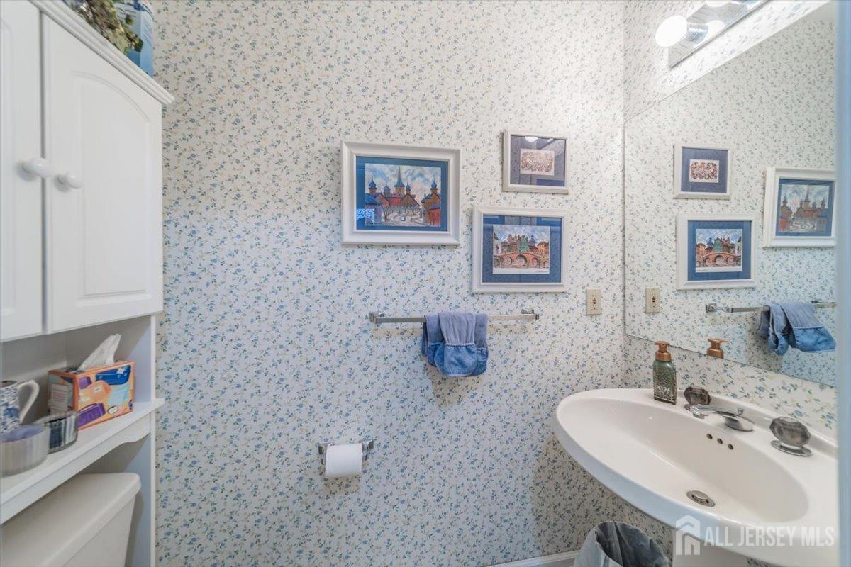 12 Adams Road Kendall Park, NJ 08824 - Photo 18 of 40 a bathroom with a sink a mirror and a toilet