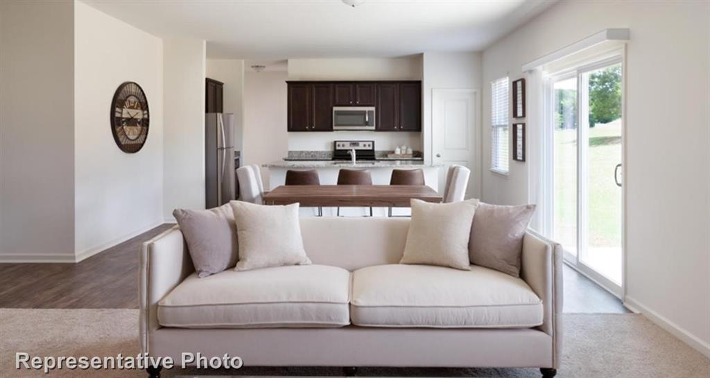 a living room with furniture a clock and a window