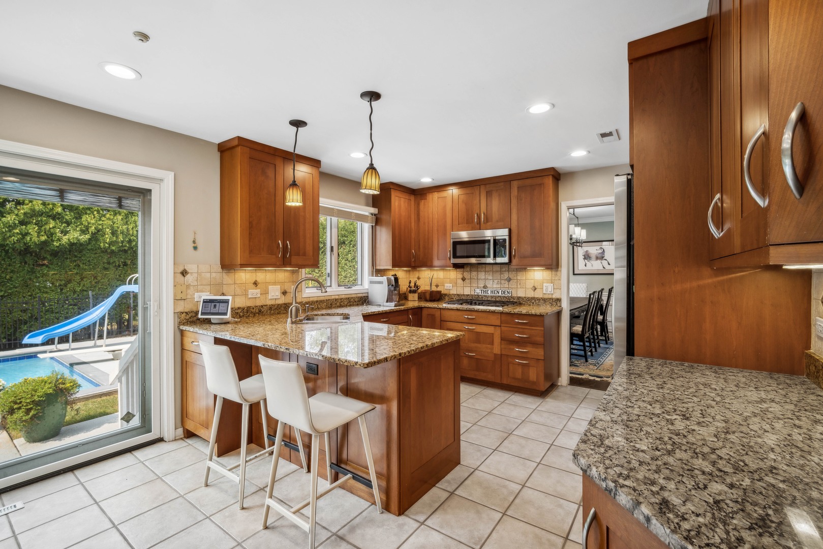 940 Sutton Drive Northbrook, IL 60062 - Photo 7 of 16 a kitchen with kitchen island granite countertop wooden cabinets a stove a sink and a refrigerator
