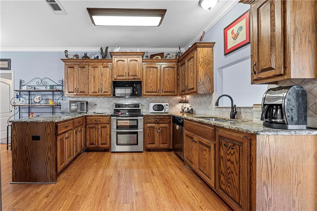 32 North Shore Circle Waco, TX 76708 - Photo 21 of 26 a kitchen with stainless steel appliances granite countertop wooden cabinets a stove top oven a sink and dishwasher