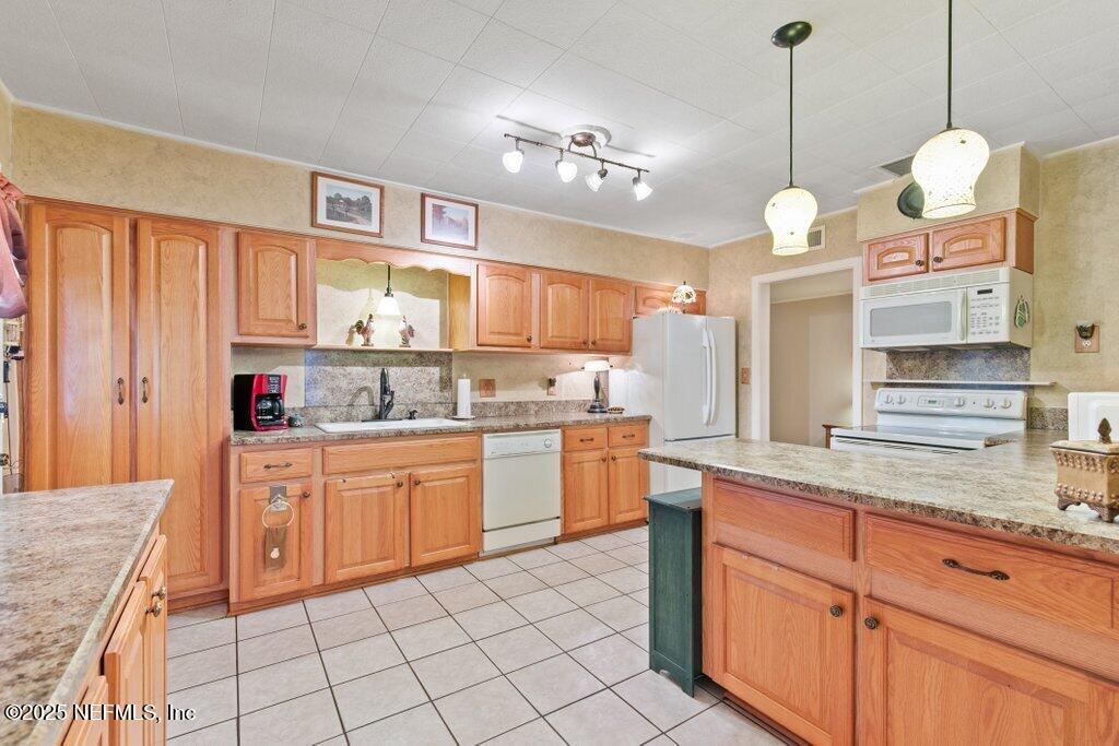 1445 Somerville Road Jacksonville, FL 32207 - Photo 36 of 49 a large kitchen with kitchen island granite countertop a sink a counter space appliances and cabinets