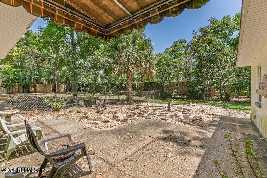 1445 Somerville Road Jacksonville, FL 32207 - Photo 42 of 49 a view of a backyard with table and chairs under an umbrella