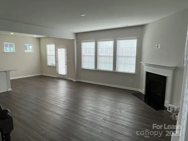 an empty room with wooden floor and fireplace