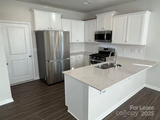 a kitchen with a sink a microwave a refrigerator and cabinets