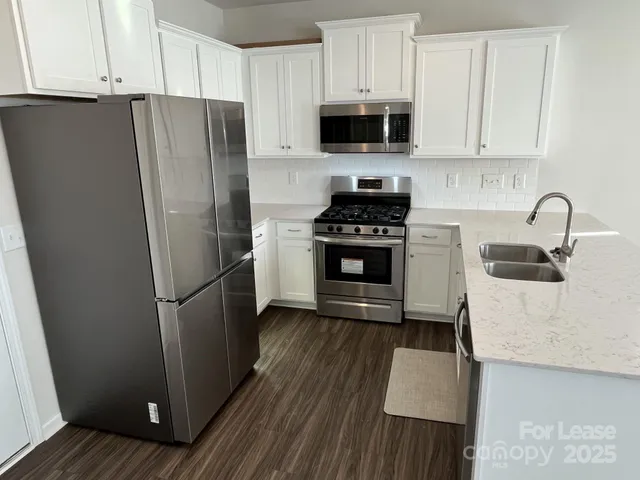 a kitchen with stainless steel appliances a refrigerator stove and sink