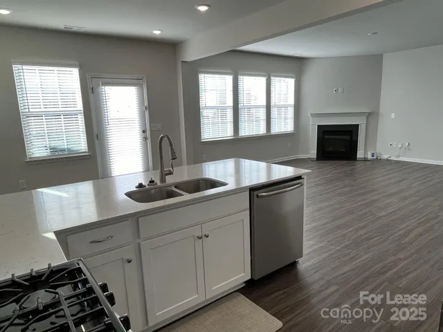 a kitchen with stainless steel appliances granite countertop a sink stove and wooden floor