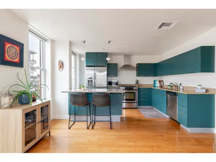 a open kitchen with stainless steel appliances kitchen island granite countertop a table and chairs in it