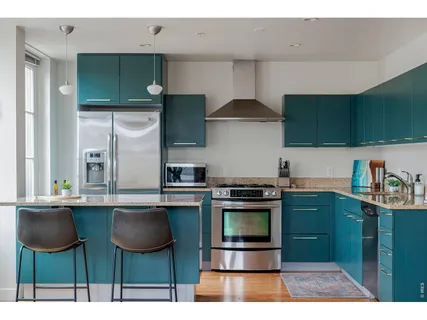 a kitchen with stainless steel appliances kitchen island a table and chairs in it