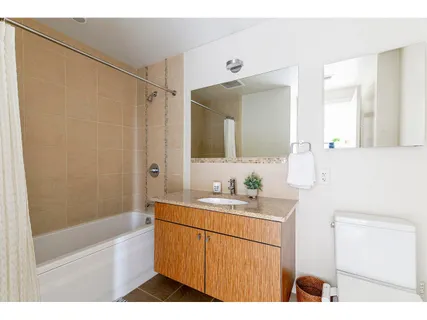 a bathroom with a sink a toilet a mirror and shower