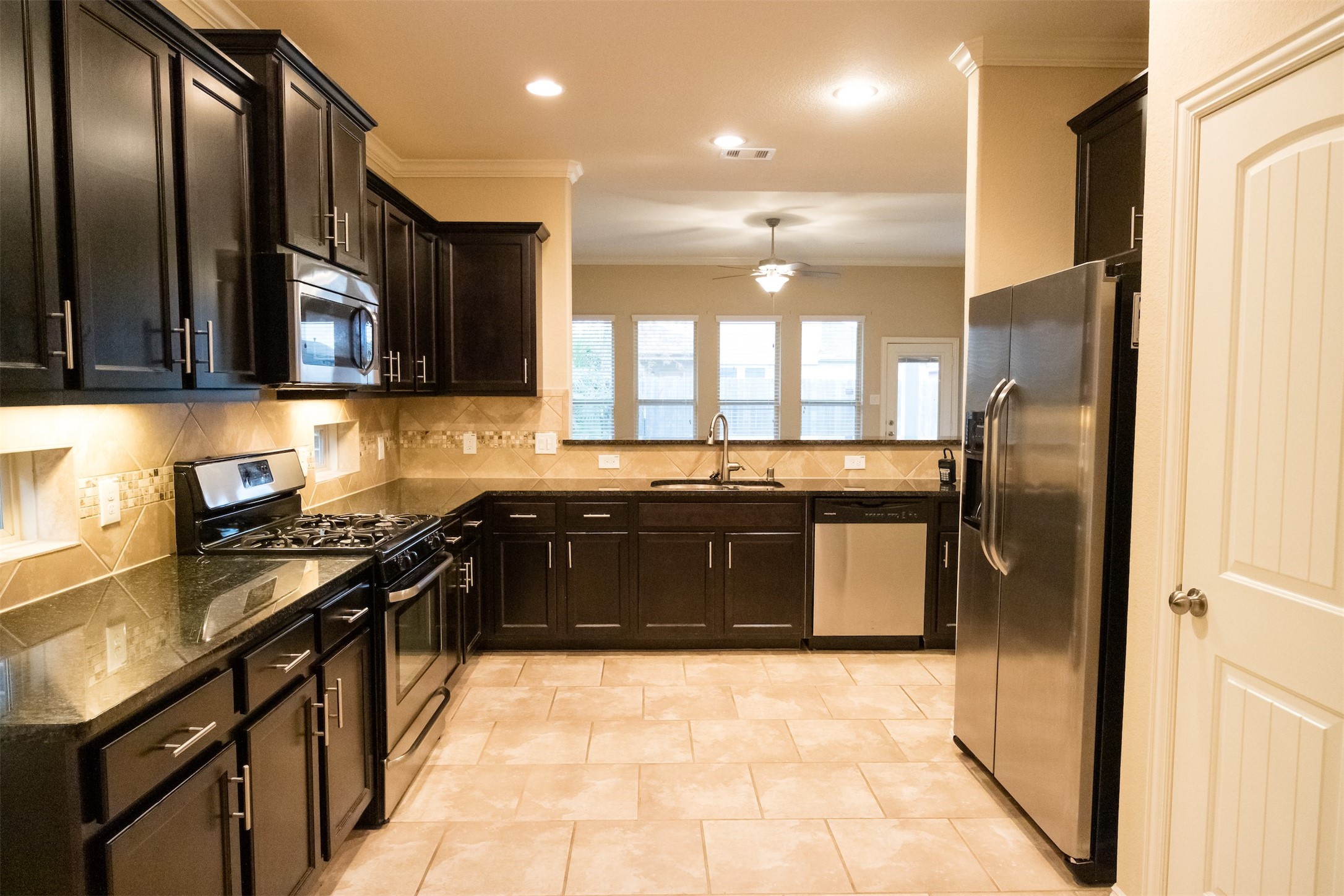 7042 Bristol Memorial Drive Spring, TX 77379 - Photo 3 of 21 a kitchen with stainless steel appliances granite countertop a stove a sink and a refrigerator