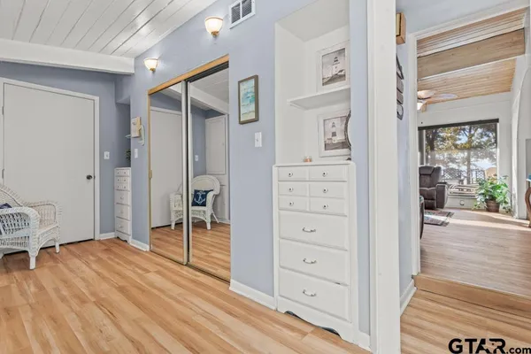wooden floor with white walls and dresser