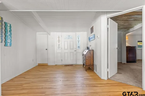 a view of a hallway with wooden floor and closet