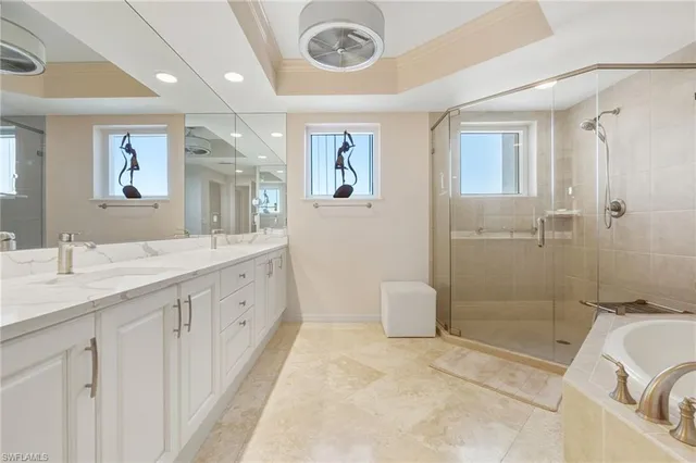 a spacious bathroom with a double vanity sink a mirror and a bathtub