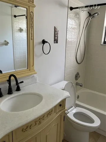 a bathroom with a sink vanity mirror toilet and bathtub