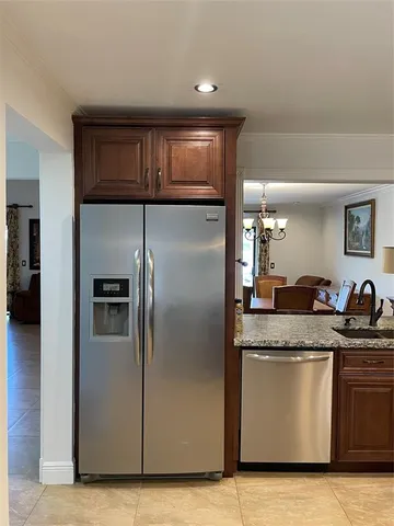 a kitchen with stainless steel appliances granite countertop a refrigerator a sink and a stove