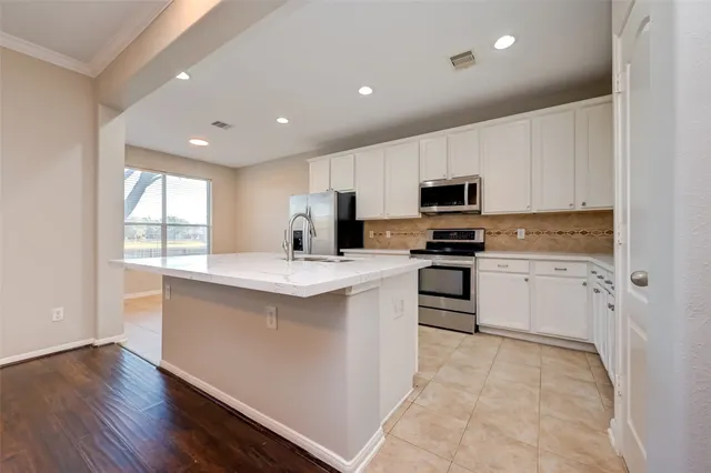 a kitchen with granite countertop white cabinets and stainless steel appliances