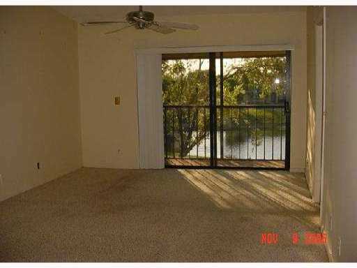 21943 Remsen Terrace, Unit 204C Boca Raton, FL 33433 - Photo 3 of 7 an empty room with wooden floor and a floor to ceiling window