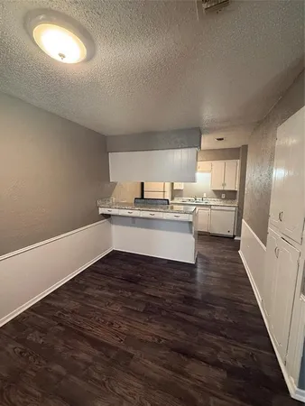 a view of a kitchen with wooden floor and electronic appliances