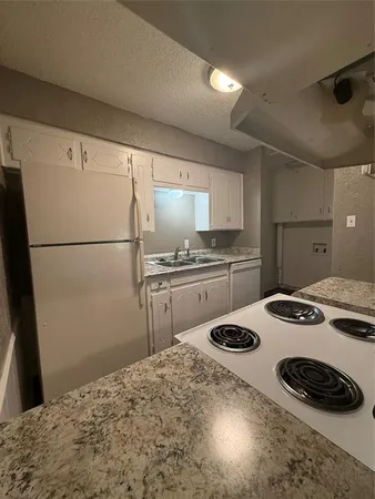 a kitchen with a appliances a stove a sink and a refrigerator