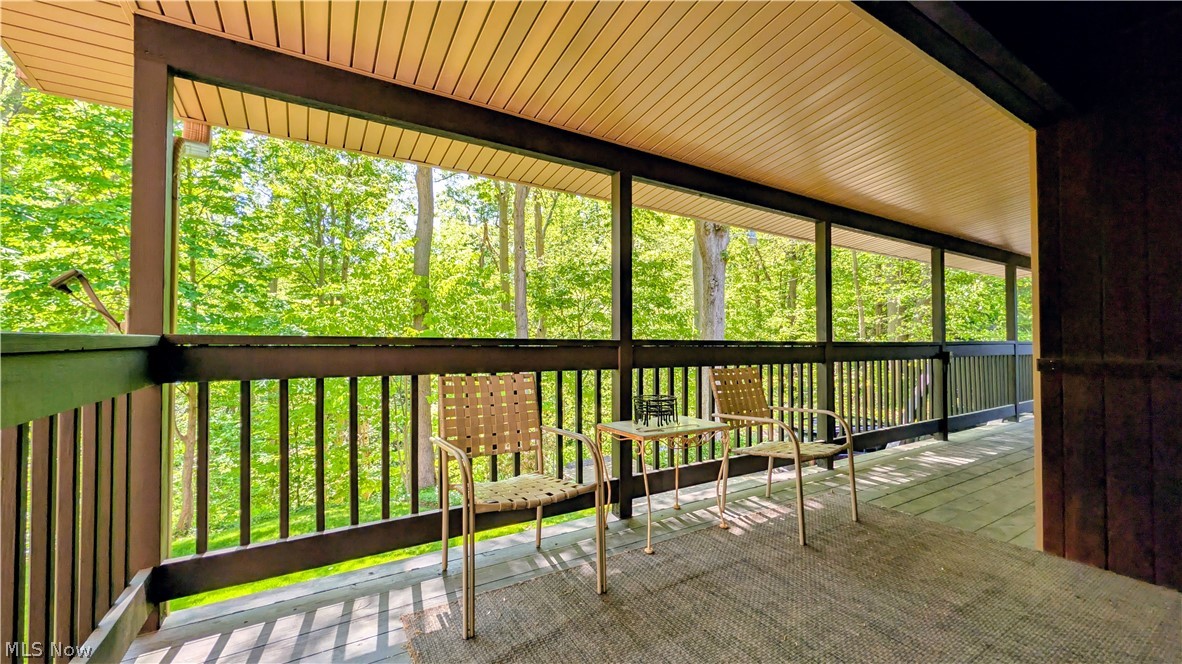 6409 Old Woods Road Ashtabula, OH 44004 - Photo 41 of 43 Expansive covered balcony featuring wood-finish flooring, a full-length railing, and a wood-paneled ceiling