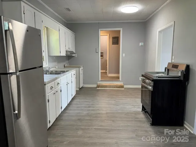 a view of a room with wooden floor and a sink