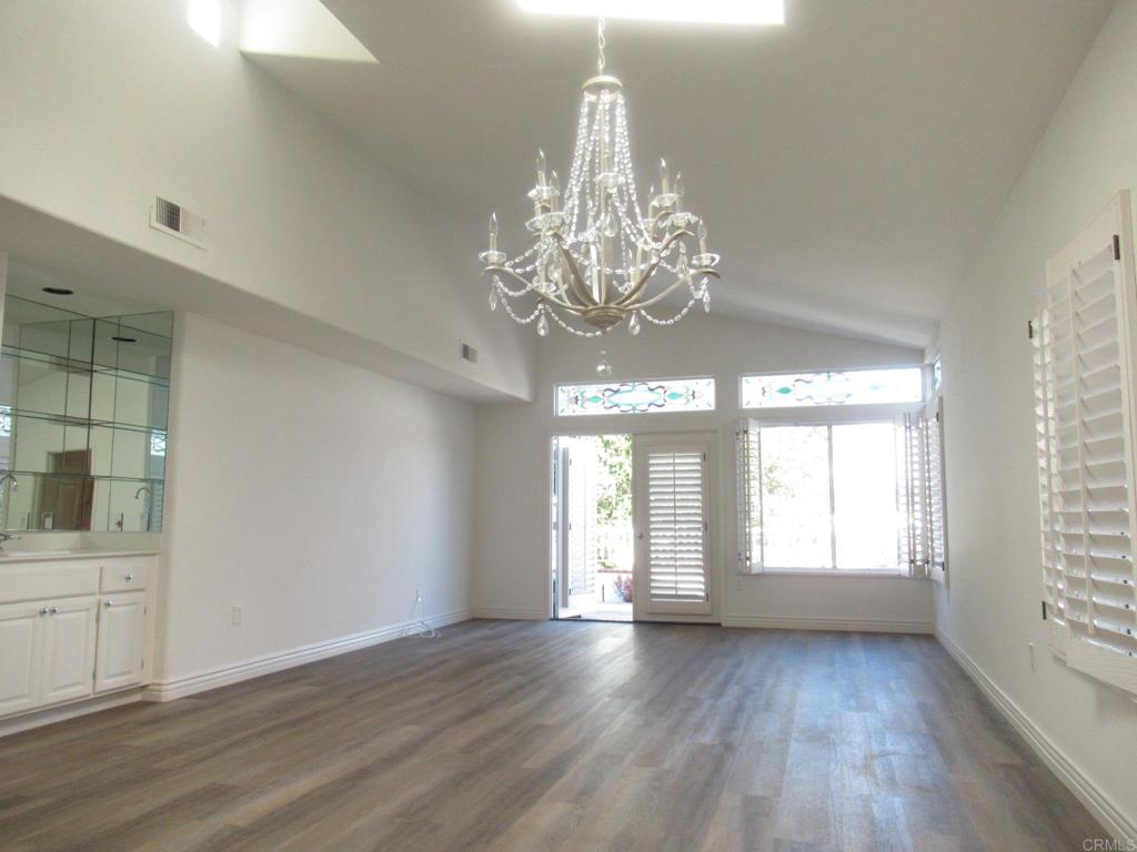4143 Andros Way Oceanside, CA 92056 - Photo 8 of 34 a view of empty room with wooden floor and kitchen view