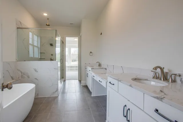a bathroom with a double vanity sink a mirror and a bathtub