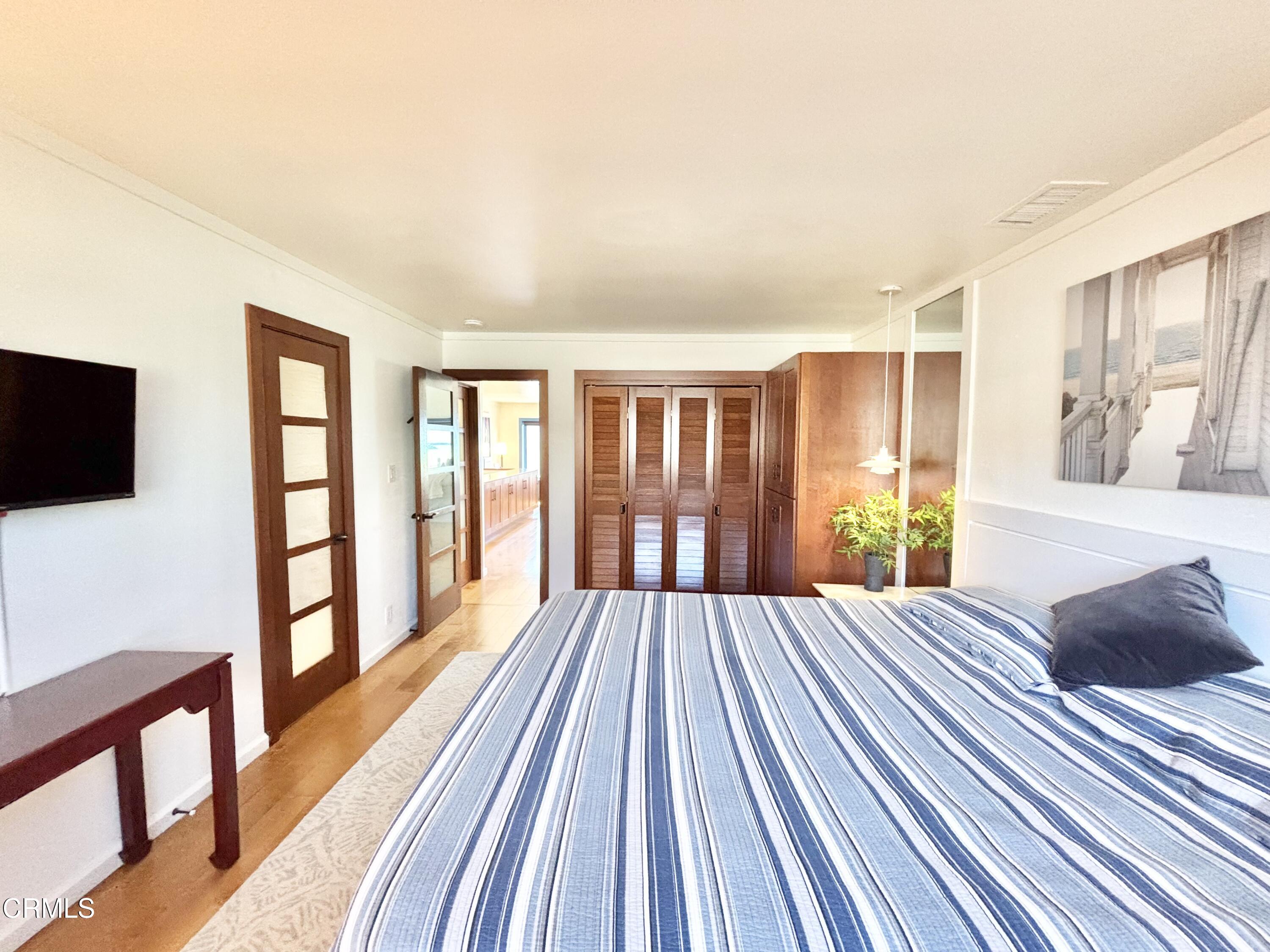 2524 Ocean Drive Oxnard, CA 93035 - Photo 14 of 28 a bedroom with a bed and wooden floor