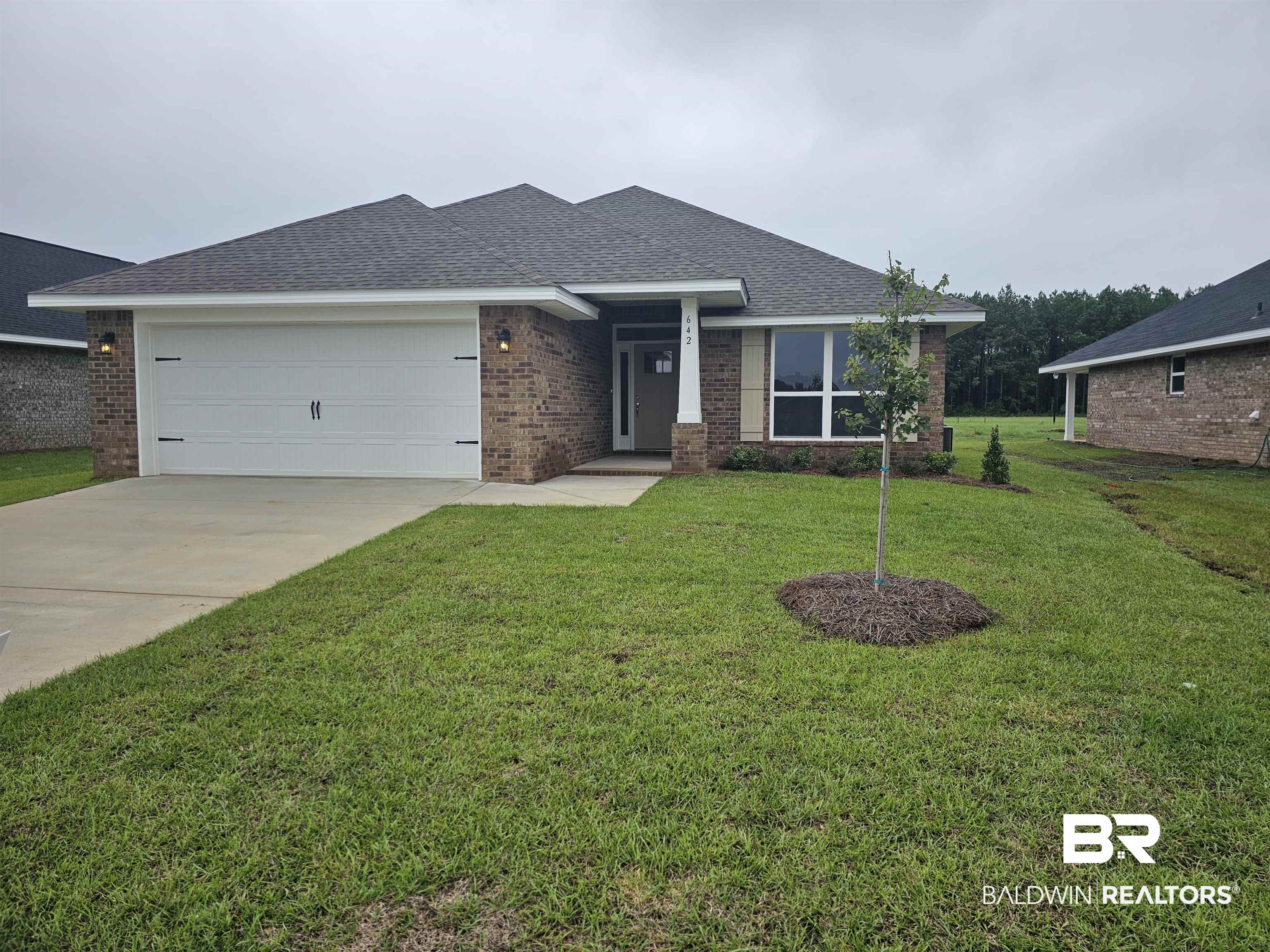 642 Revere Street Foley, AL 36535 - Photo 2 of 27 View of front facade with a front yard and a garage