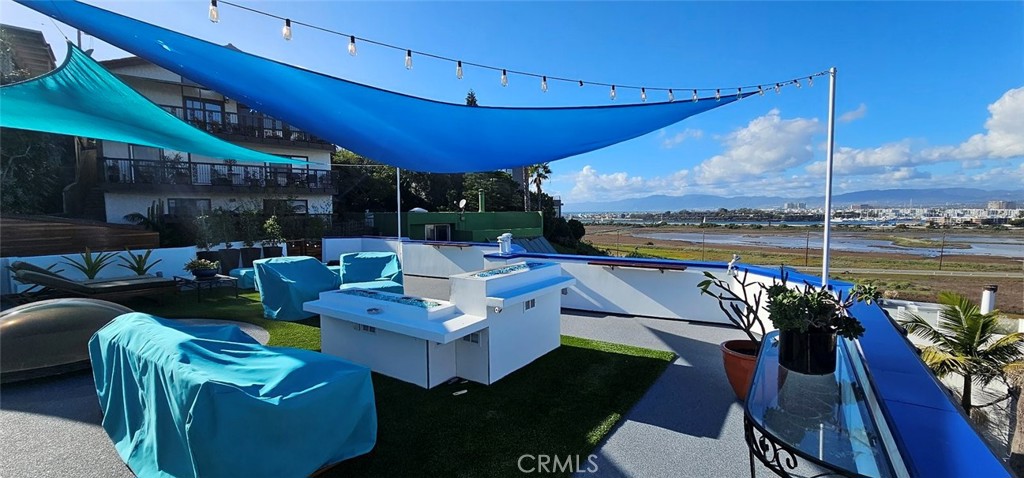 8109 Sinaloa Road Playa del Rey, CA 90293 - Photo 3 of 19 a view of a patio with couches chairs dining table and chairs under an umbrella with a patio
