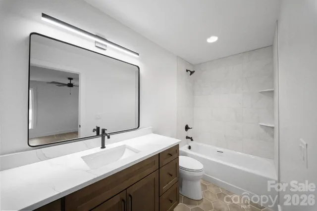 a bathroom with a double vanity sink toilet mirror and bathtub