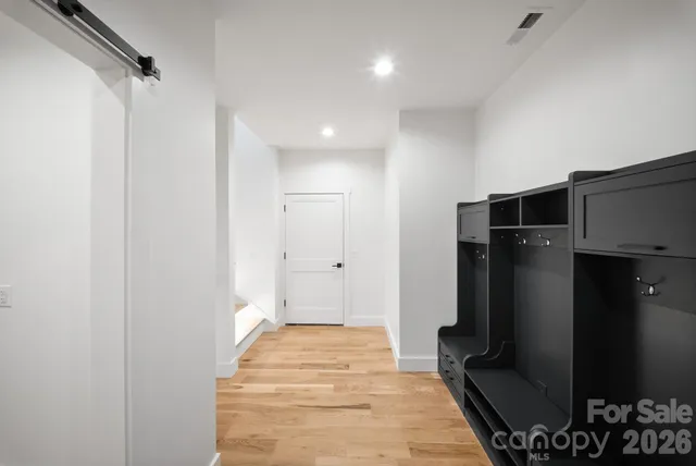 a room with stainless steel appliances wooden floor and staircase
