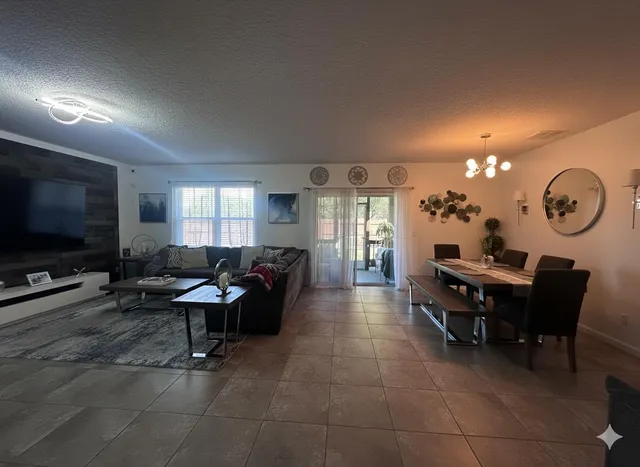 a living room with furniture a flat screen tv and a dining table