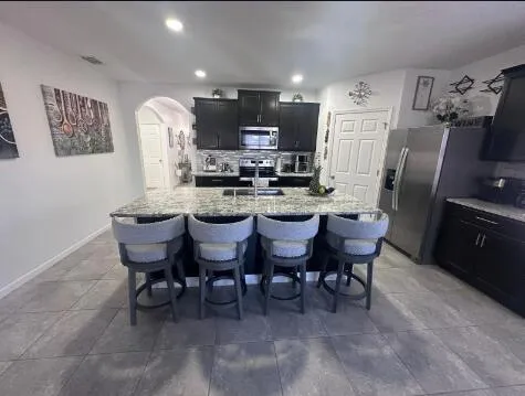 a kitchen with stainless steel appliances kitchen island granite countertop a sink and cabinets