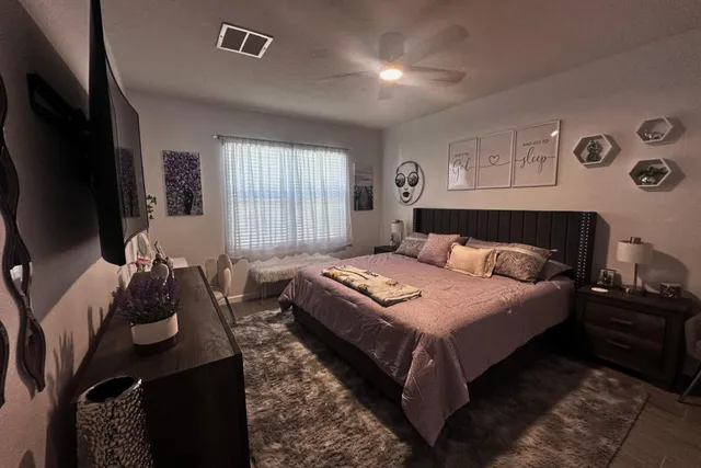 a bedroom with bed couch and window