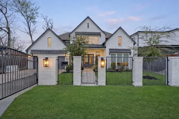 a front view of a house with a garden and plants