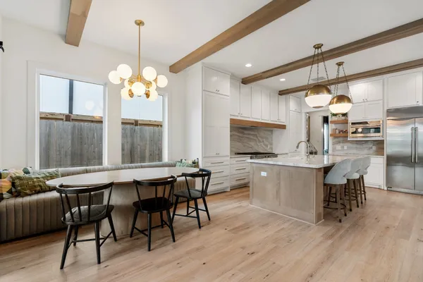 a living room with furniture a large window and wooden floor