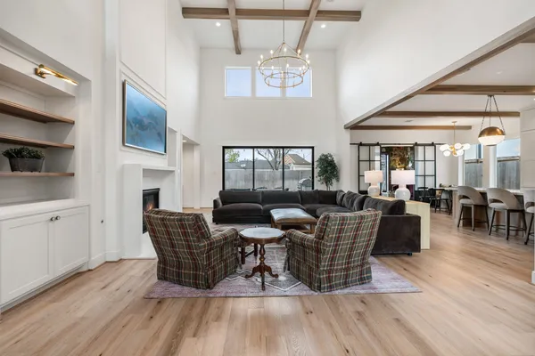 a living room with furniture a chandelier and a fireplace