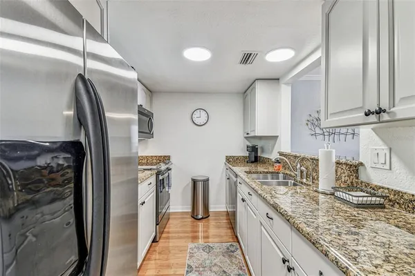 a kitchen with stainless steel appliances granite countertop a sink a stove and a microwave