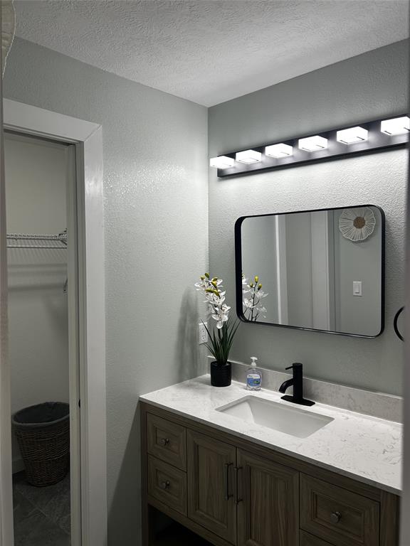 908 West Chestnut Street Denison, TX 75020 - Photo 14 of 19 a bathroom with a double vanity sink and a mirror