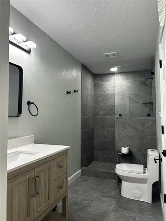 a bathroom with a sink a toilet and shower
