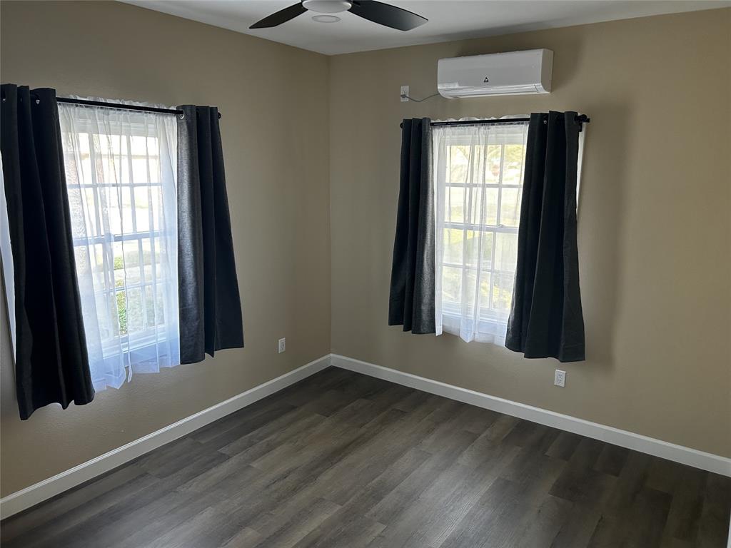 908 West Chestnut Street Denison, TX 75020 - Photo 7 of 19 an empty room with wooden floor and windows