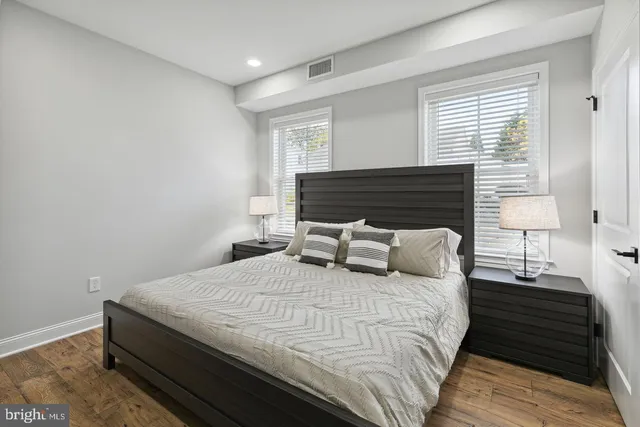 a bedroom with a bed and wooden floor